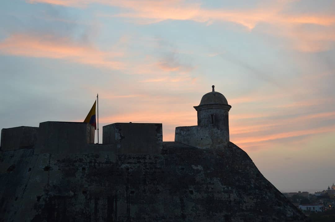 Cielo de atardecer con tonos rosados detrás del Castillo de San Felipe de Barajas